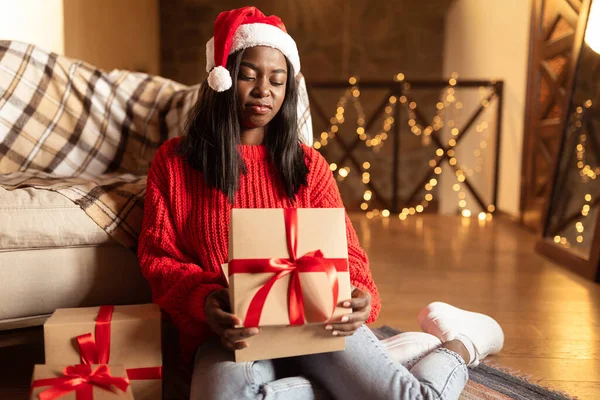 Infelice giovane donna nera apertura scatole regalo di Natale, insoddisfatto con regali di Natale a casa, spazio copia — Foto Stock