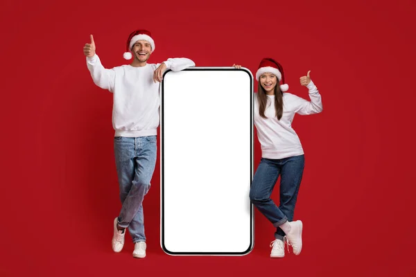 Online προσφορά. Νεαρό ζευγάρι σε Σάντα Καπέλα στέκεται κοντά στο μεγάλο κενό Smartphone — Φωτογραφία Αρχείου