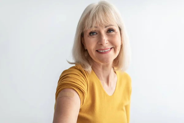 Vaccinated Mature Lady Showing Arm With Plaster On Gray Background — Stock Photo, Image