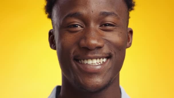 Kameraya gülümseyen, mutlu ve kaygısız genç Afro-Amerikan 'ın yakın portresi. — Stok video