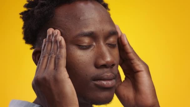 Ataque de migraña. Retrato semi-perfil del joven afroamericano que sufre de dolor de cabeza, masajeando sus sienes — Vídeos de Stock