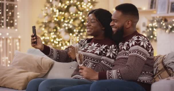 아프리카 계 미국인 커플 이 친구들 과 잡담하며 샴페인 잔으로 전화를 하고 축하를 하는 모습. — 비디오