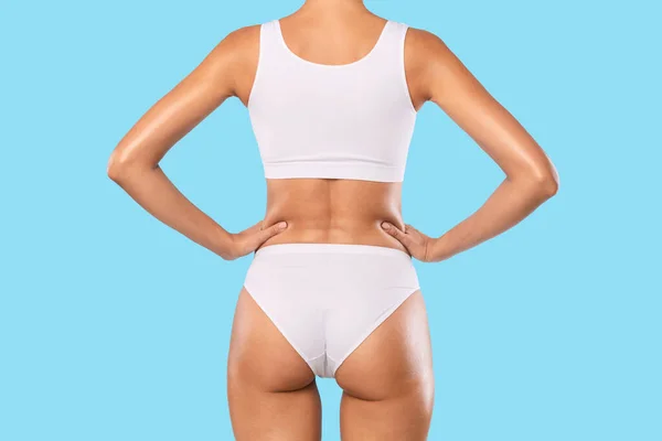 Rückansicht einer jungen schlanken Frau in weißer Unterwäsche — Stockfoto