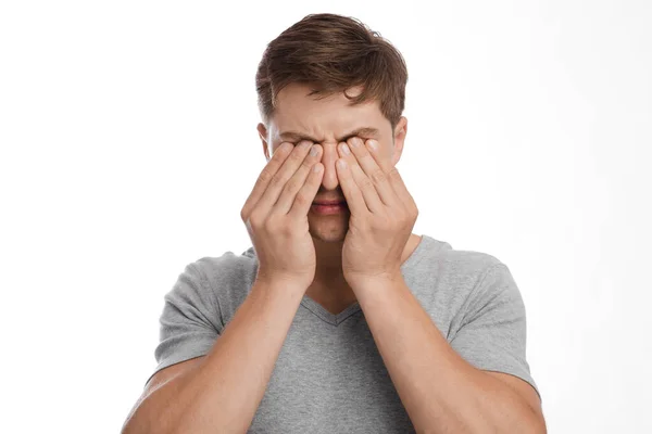 Agacé fatigué jeune homme caucasien triste frotte les yeux, souffre de sécheresse, isolé sur fond blanc — Photo