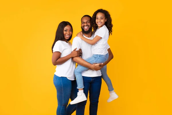 Homem negro feliz posando com esposa e filha sorridente — Fotografia de Stock