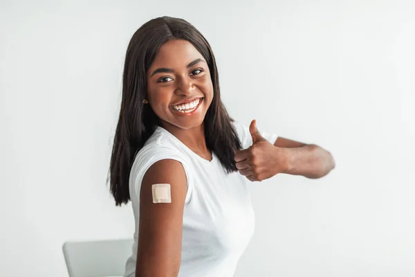 黑色注射疫苗的女性肩带带补丁和拇指向上 — 图库照片