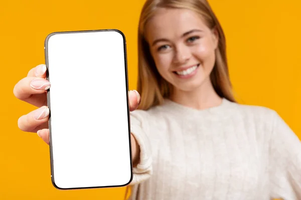 Крупный план мобильного телефона с пустым экраном в руке юной леди — стоковое фото