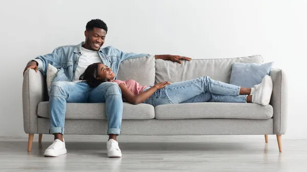 Afrykańska para spędza razem weekend leżąc na kanapie — Zdjęcie stockowe