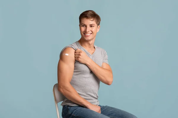Fröhlich junge muskulöse attraktive europäische Kerl zeigt Hand mit Band Hilfe nach der Injektion — Stockfoto