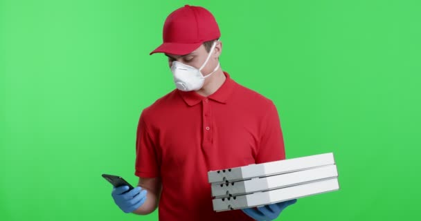 Курьер в защитной маске отмечает доставку в мобильном приложении — стоковое видео