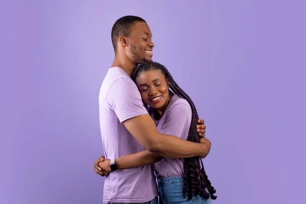 Hombre afroamericano abrazando a su encantadora mujer en el estudio — Foto de Stock