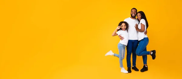 アフリカ系アメリカ人の男が妻と興奮した娘を抱きかかえて — ストック写真