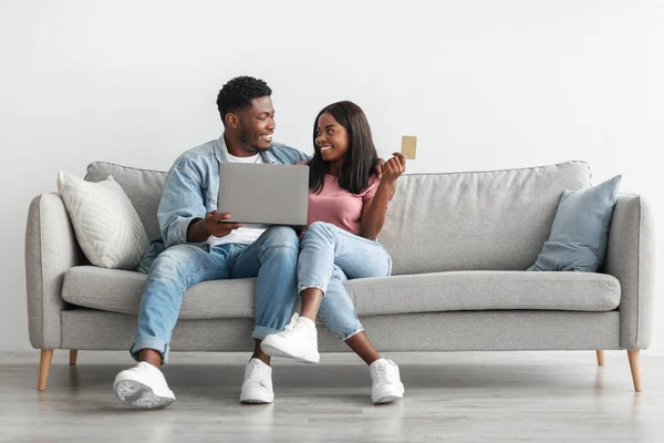 Casal preto usando pc e cartão de crédito em casa — Fotografia de Stock