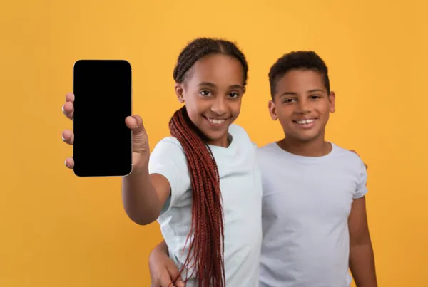 Schattig Afrikaans amerikaans kinderen tonen smartphone met leeg scherm — Stockfoto