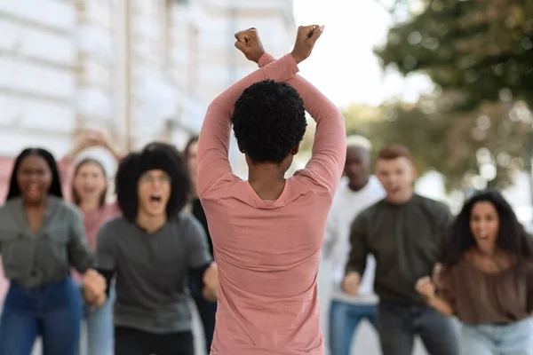 Vista trasera de una activista afroamericana que lidera a manifestantes enojados — Foto de Stock