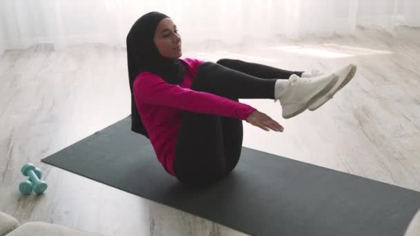 Bauchmuskeltraining. Junge aktive Mittlere-Osten-Dame mit traditionellem Kopftuch übt volle Crunches — Stockvideo