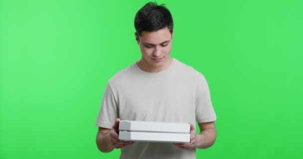 Lezzetli pizza kokusundan hoşlanan genç adam, elinde fast food kutuları tutuyor. — Stok video
