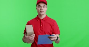Paketi olan arkadaş canlısı kurye kameraya not defteri veriyor.