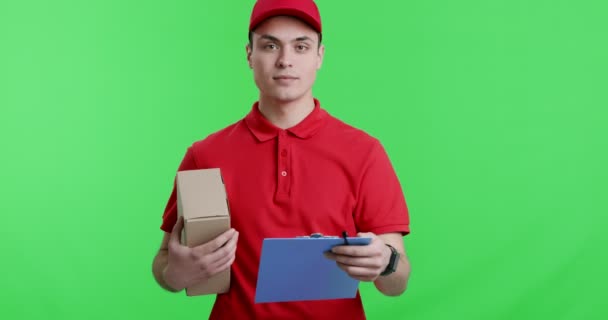 Vriendelijke koerier met pakket geven notitieblok aan camera een — Stockvideo