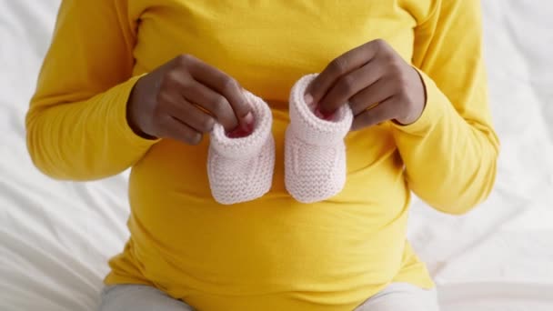 Preto grávida senhora jogar com pequeno bebê shoes, pisando no seu barriga — Vídeo de Stock