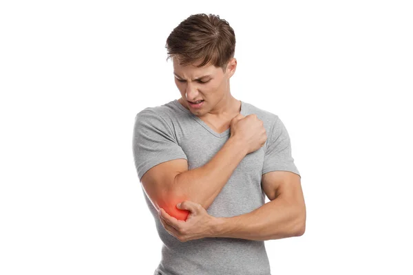 Triste joven atleta caucásico chico que sufre de dolor de codo, presiona la mano al punto dolorido, se muestra en rojo — Foto de Stock