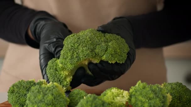 Irreconocible rompiendo brócoli en floretes cocinar en cocina moderna, recortado — Vídeo de stock