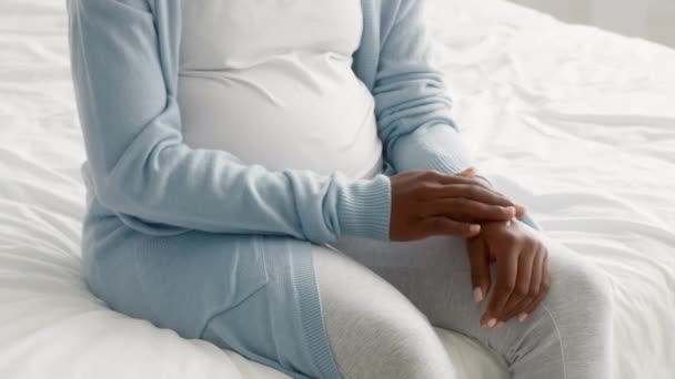 Беременная кожа. Крупный план черной беременной женщины, наносящей увлажняющий крем на руки — стоковое видео