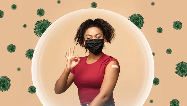 Heureuse femme millénariste noire en masque montre épaule avec pansement après la vaccination et geste correct — Photo