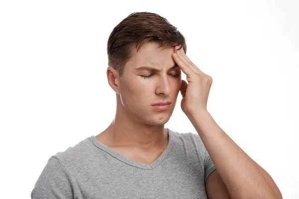 Zoufalý smutný atraktivní mladý běloch trpící bolestí hlavy, dotýkající se čela, izolovaný na bílém pozadí — Stock fotografie