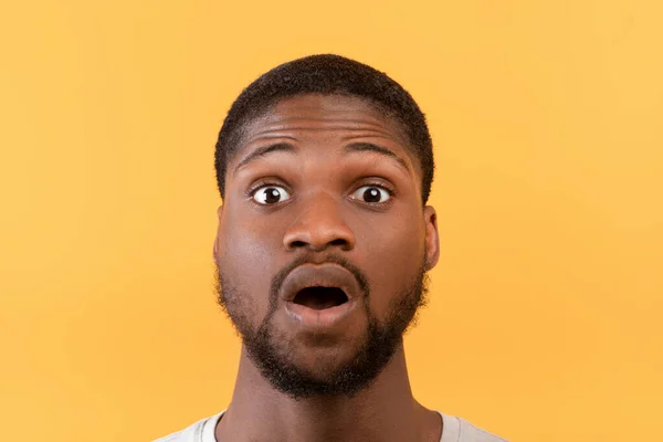 Incroyable nouvelle. Portrait de l'homme noir ouvrant la bouche et les yeux en état de choc, regardant la caméra sur fond jaune — Photo