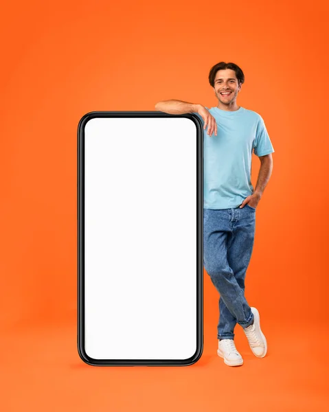 Büyük beyaz akıllı telefon ekranına yaslanan sıradan bir adam. — Stok fotoğraf
