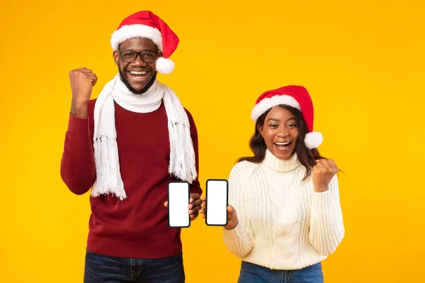 Pareja Negra Mostrando Smartphones Gestos Sí Usando Sombreros de Santa, Estudio — Foto de Stock