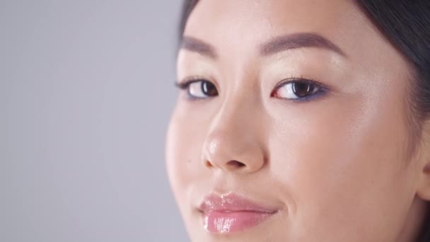 Koreai kozmetikumok. Közelkép portré gyönyörű ázsiai hölgy tökéletes smink fordult kamera és mosolygós — Stock videók