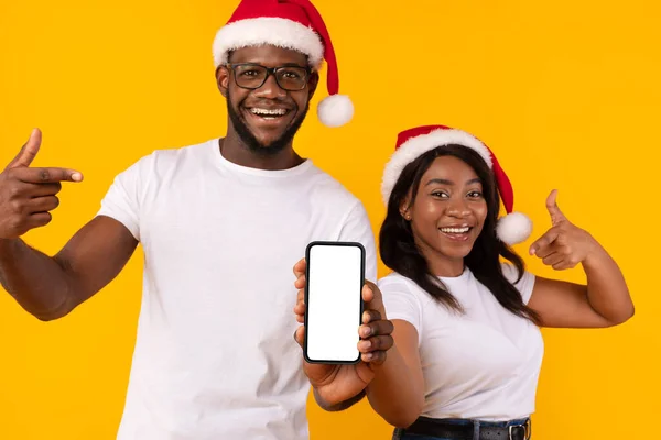 Black Couple Showing Phone Blank Screen Advertising Christmas Offer, Studio — Stock Photo, Image