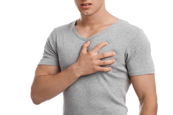 Gescheurde jonge gespierde Europese man die lijdt aan pijn op de borst, drukt hand aan hand tot zere plek — Stockfoto