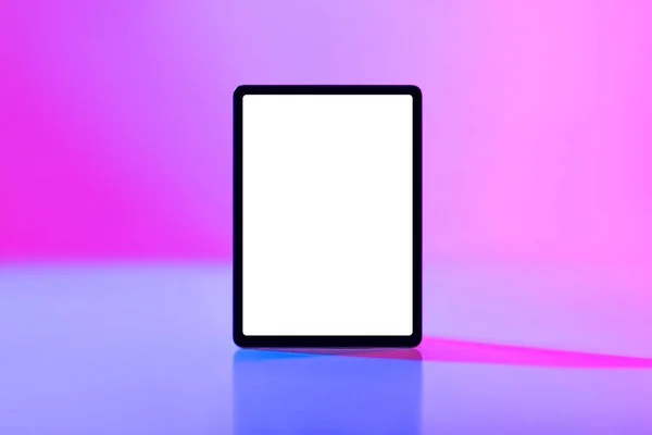 Moderne tablet computer met mockup voor toepassing of website op blanco wit scherm in neon licht — Stockfoto