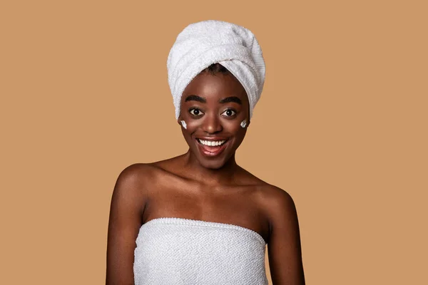 Hermosa joven negra posando con crema en la mejilla —  Fotos de Stock