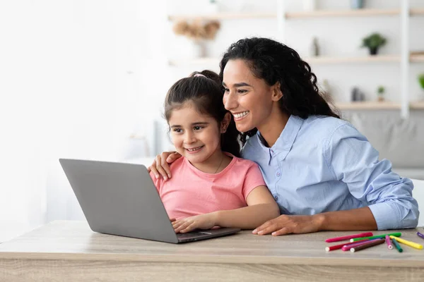 Онлайн-образование. Маленькая девочка и ее красивая мама с ноутбука дома — стоковое фото