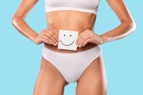 Kvinnan håller papper klisterlapp med glad smiley ansikte — Stockfoto