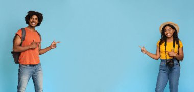 Neşeli siyah erkek ve kadın gezginler boş alan gösteriyor