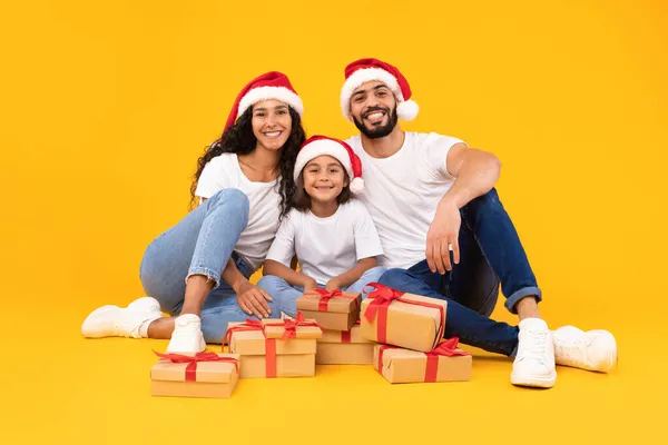 Happy Arab Family Sitting Among Xmas Presents Boxes, Yellow Background — Stock Photo, Image