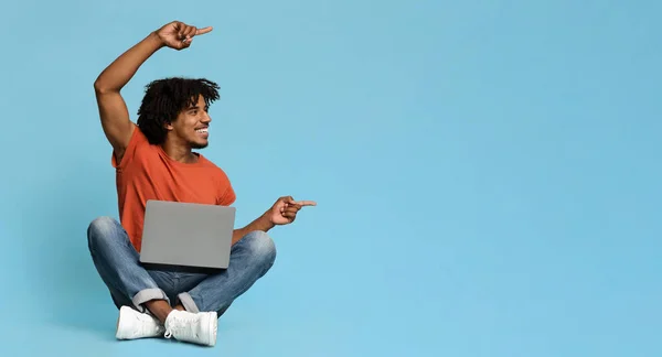 Homem negro feliz com laptop apontando para o espaço de cópia — Fotografia de Stock