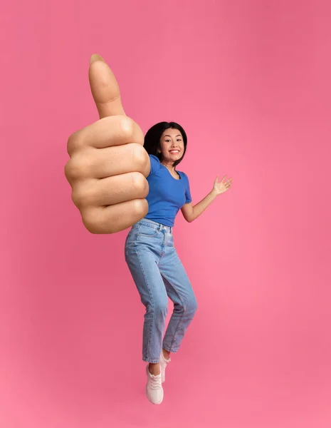 Емоційна корейська жінка підстрибує і показує великий палець вгору — стокове фото