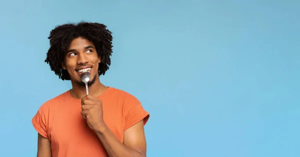 Цікавий афроамериканець з ложкою в роті. — стокове фото
