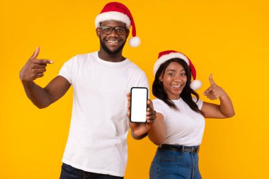 Siyah Çift Noel Baba Şapkası Giyiyor Cep Telefonu Ekranı Gösteriyor, Sarı Arkaplan
