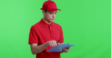 Evrakları dolduran, kameraya gülümseyen genç bir işçi.