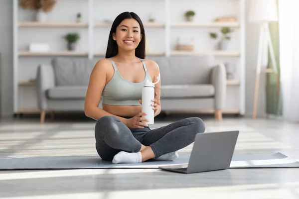 Portret uśmiechniętej młodej Azjatki trenującej z laptopem w domu — Zdjęcie stockowe