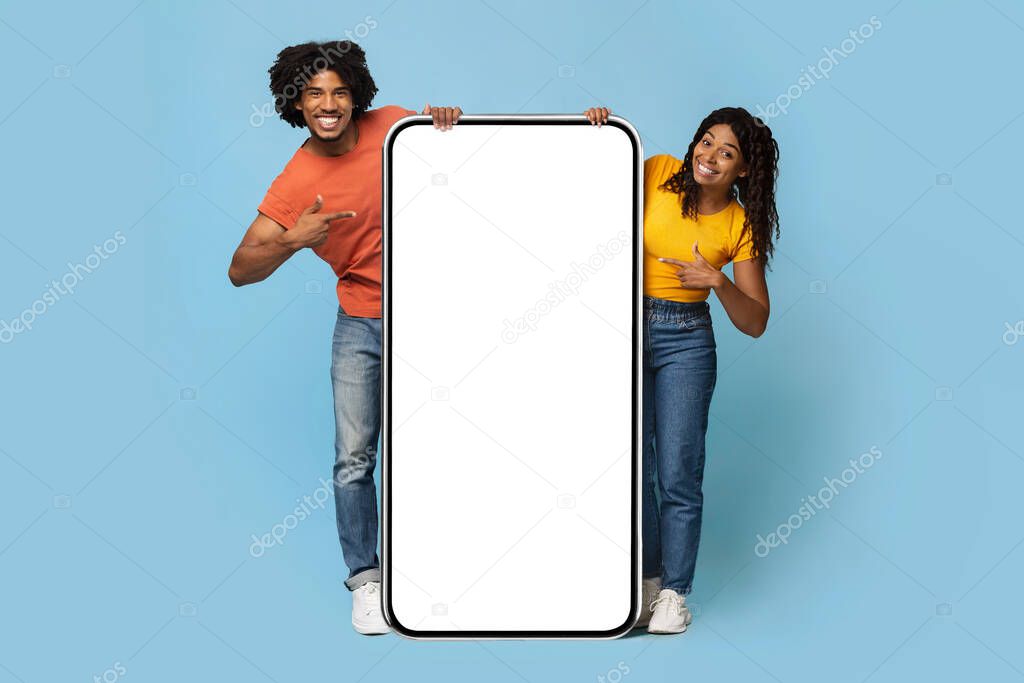 Cheerful black couple posing with big smartphone, mockup