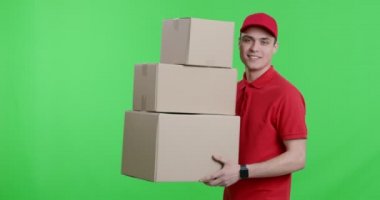 Kırmızı üniformalı bir kurye paketle yürüyor.