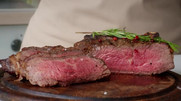 Chef streut Salz auf Beefsteak Gewürzfleisch in der Küche, beschnitten — Stockvideo